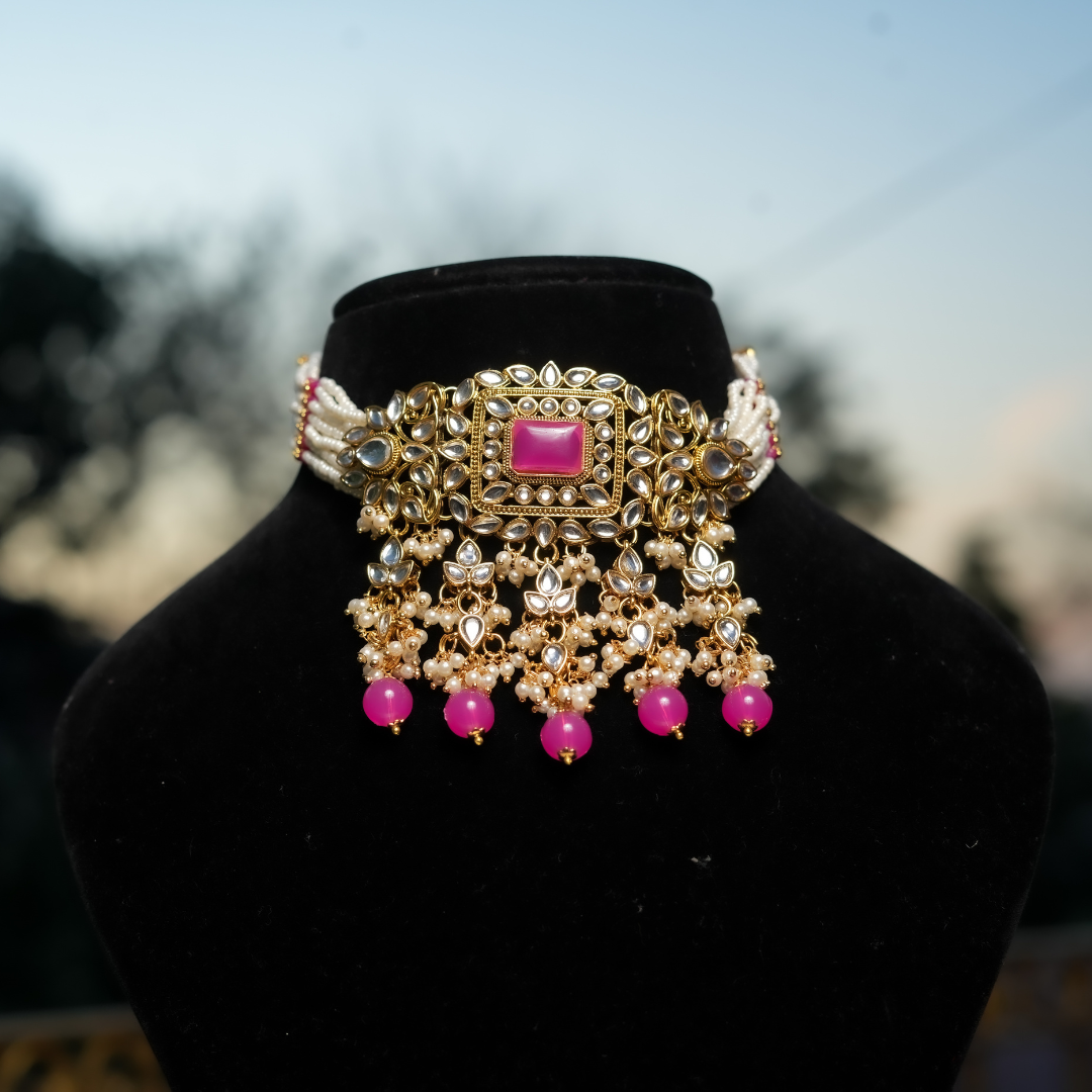 A traditional Indian petal pink kundan necklace set with gold-colored metal and pink stone accents