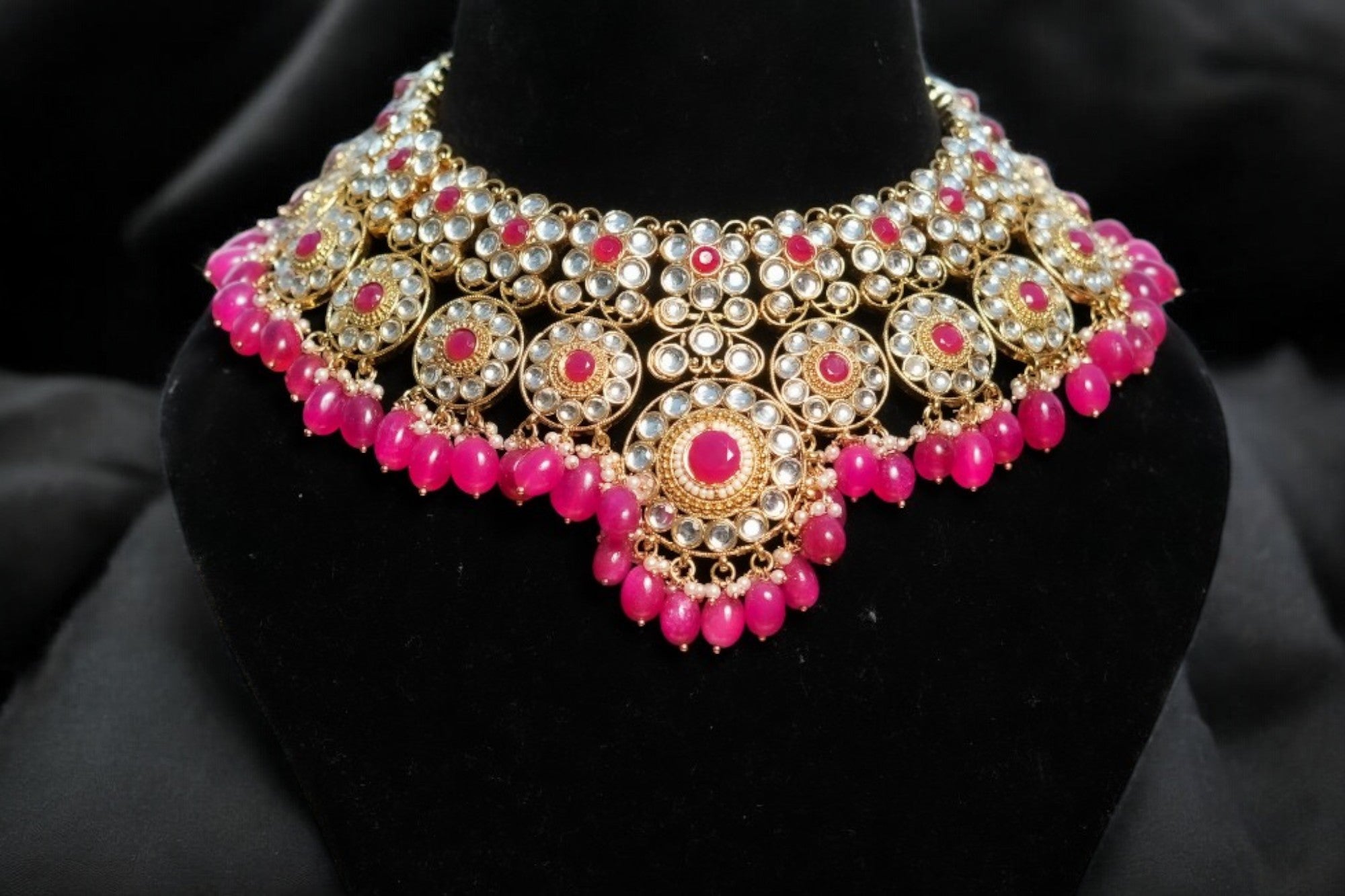 A rose pink kundan necklace set with intricate gold detailing