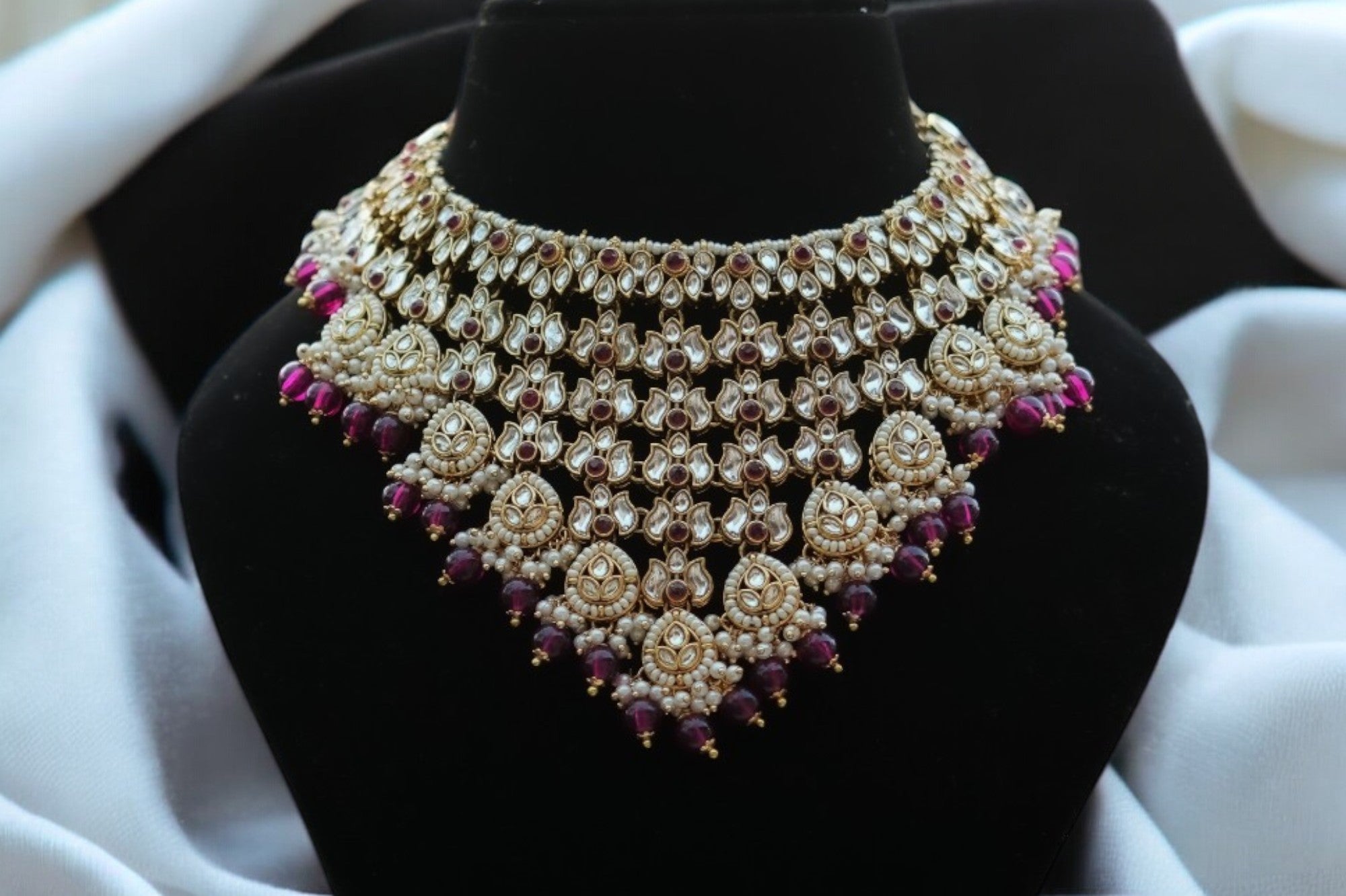 A maroon and gold-coloured kundan necklace set