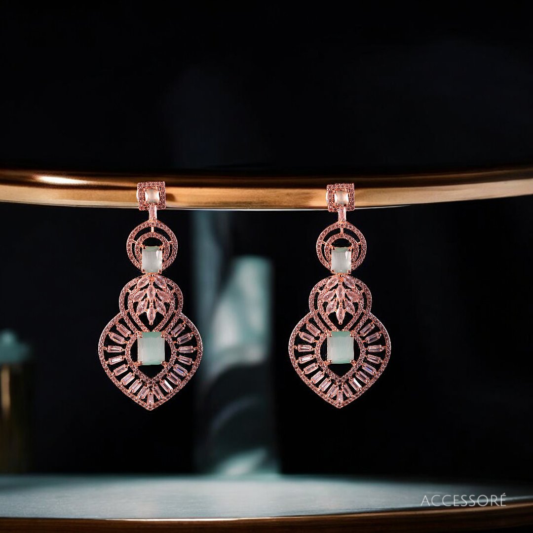 A pair of oxidized gold earrings with intricate detailing