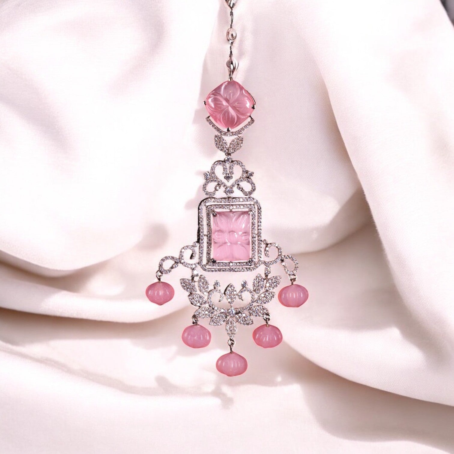 A pink chandelier earring with intricate design