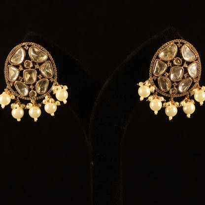 A pair of gold-colored earrings featuring pearl accents and intricate detailing