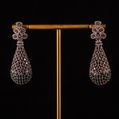 Silver diamond drop earrings with frosted finishes and pine inspired details with tiny emerald stones