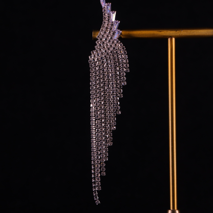 A pair of long, silver, diamond gilded earrings with a crystal design