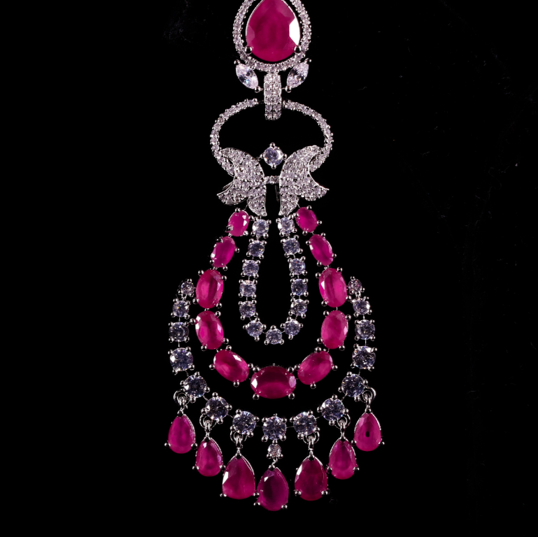 Ornate jewellery piece with ruby pink gemstones and silver diamond accents