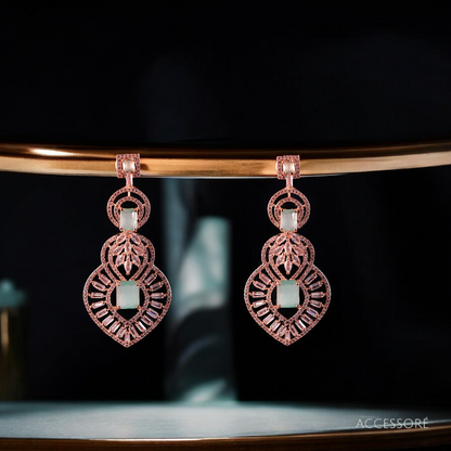 A pair of oxidized gold earrings with intricate detailing
